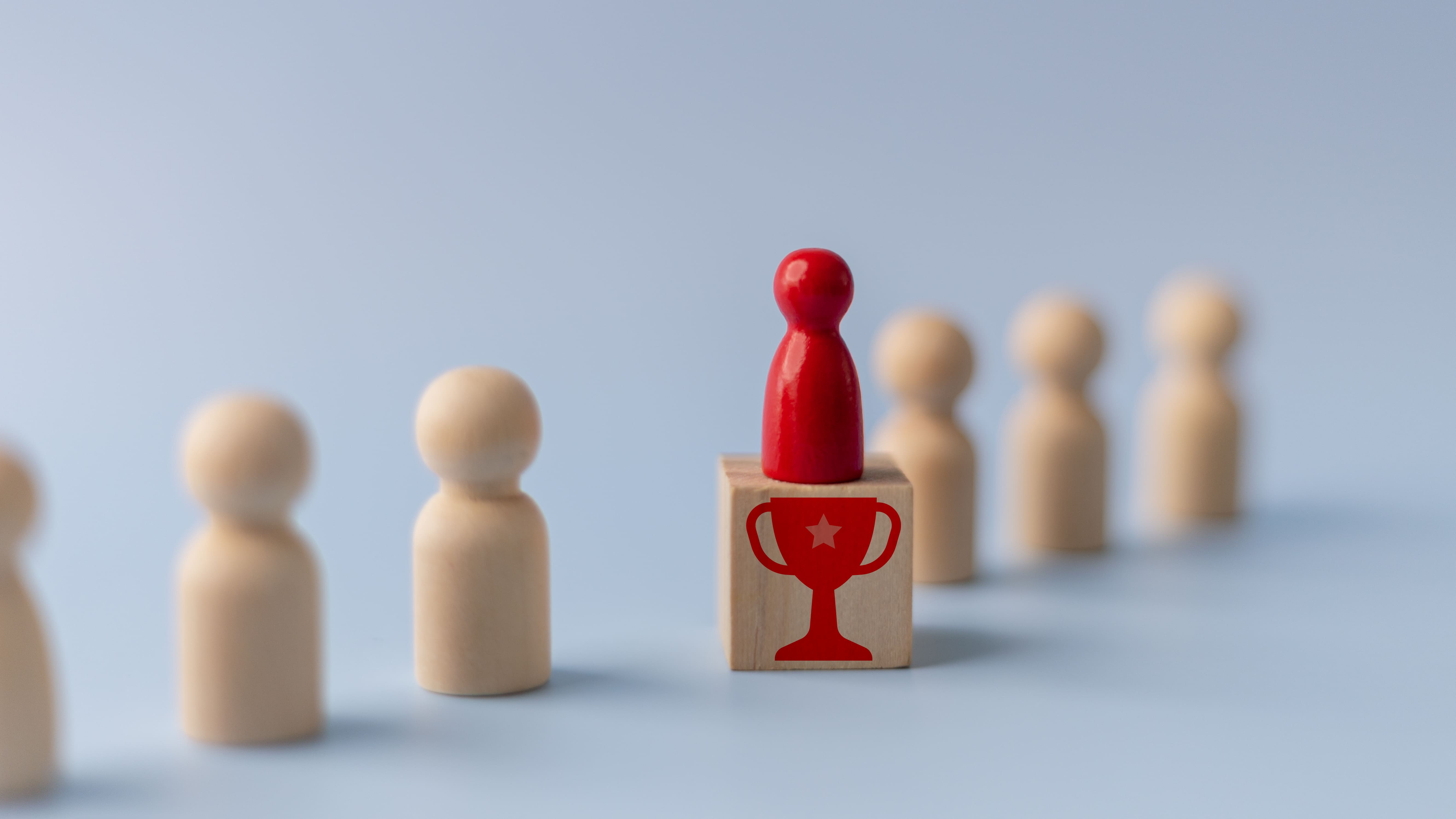A single red leader figure standing apart on a marked block above a line of uniform figures, representing a high-performance organization that out-executes everyone else