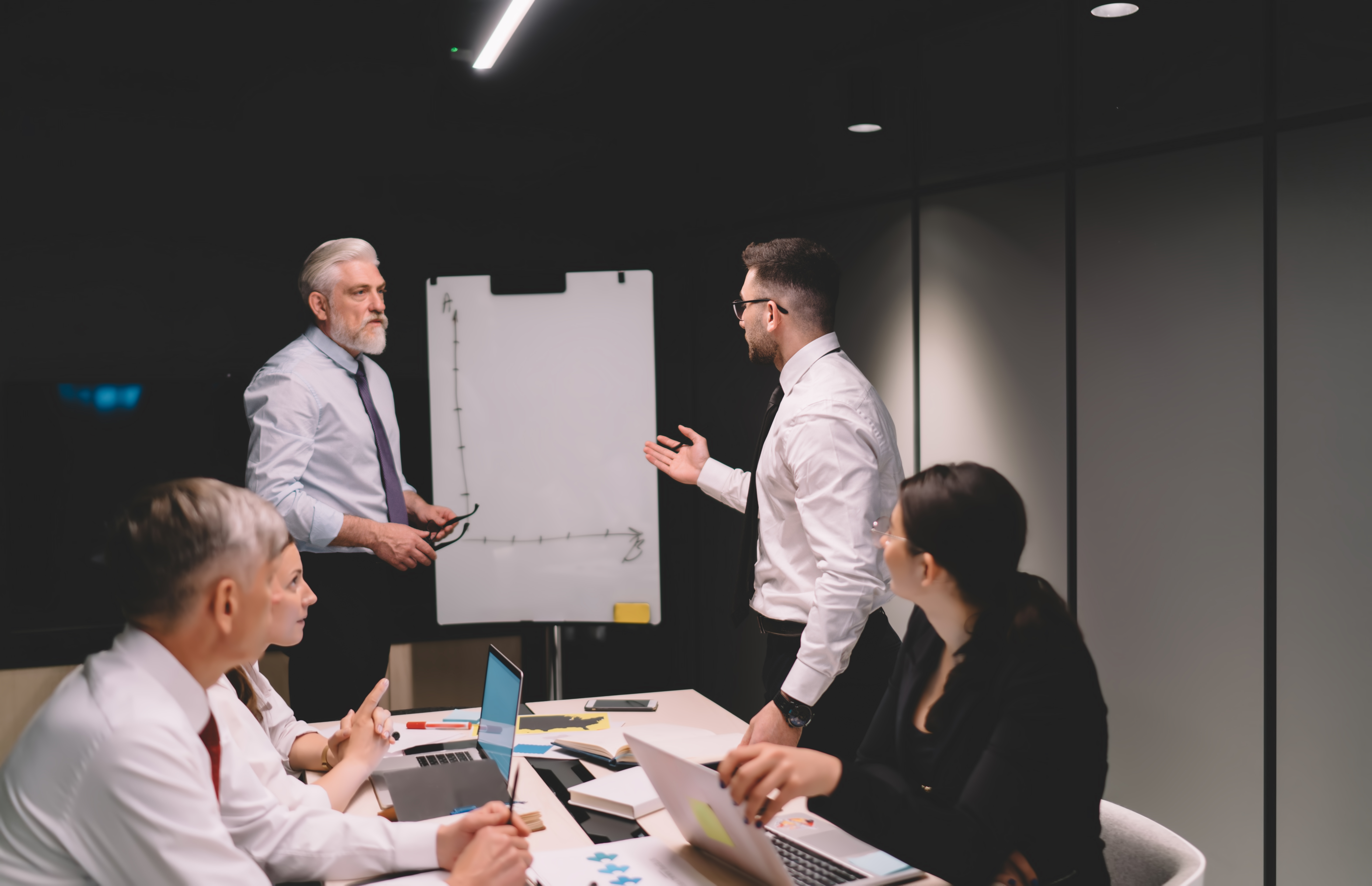 Male employee asking boss questions during a coaching leadership meeting